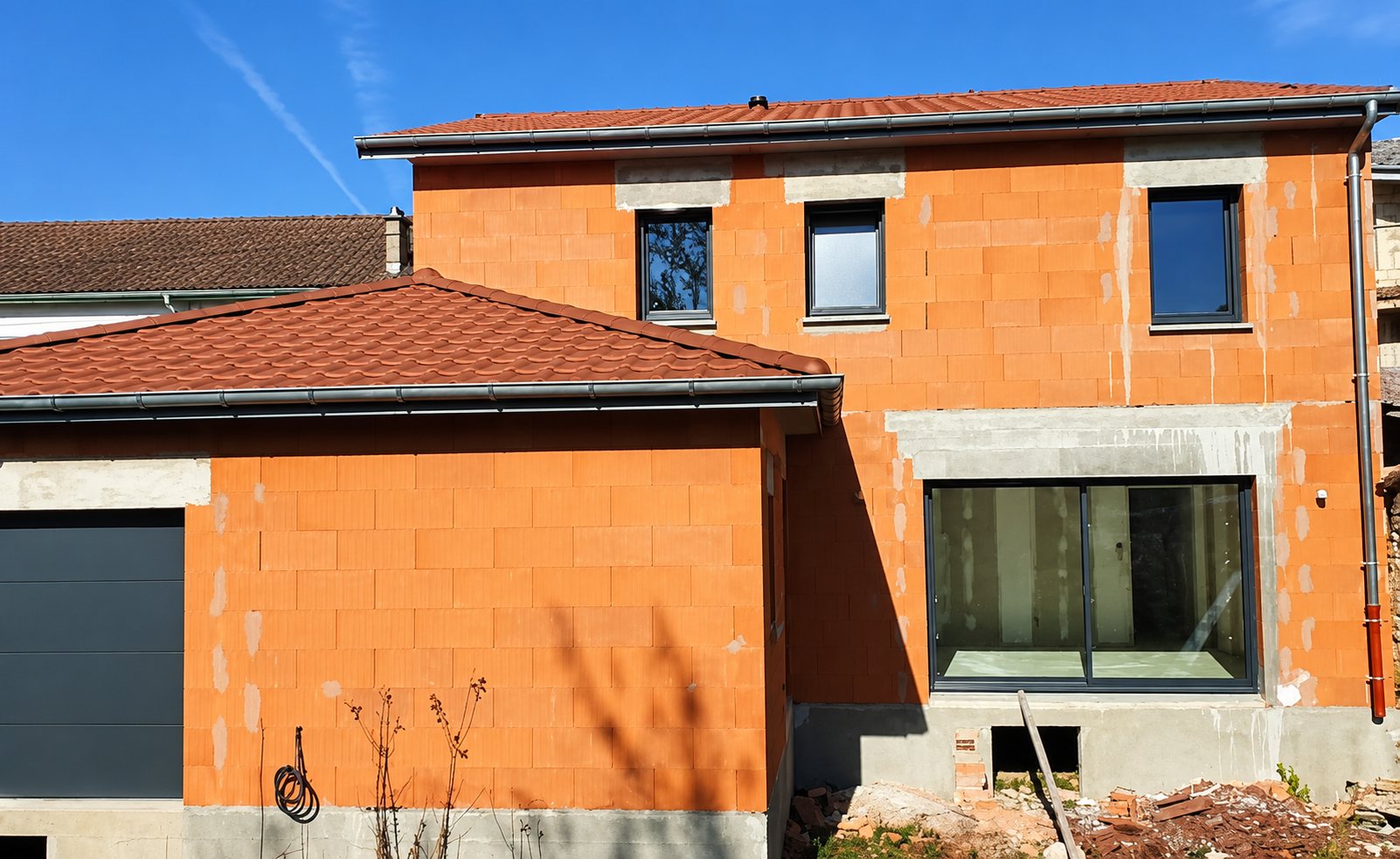 Maison à étage en briques rouges et toit de tuiles en cours de construction
